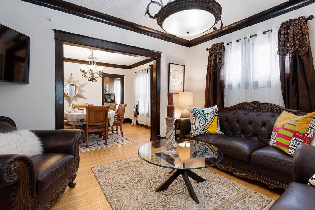 明尼阿波利斯AMAZING TRADITIONAL HOME SOUTH MINNEAPOLIS的客厅配有真皮沙发和玻璃桌