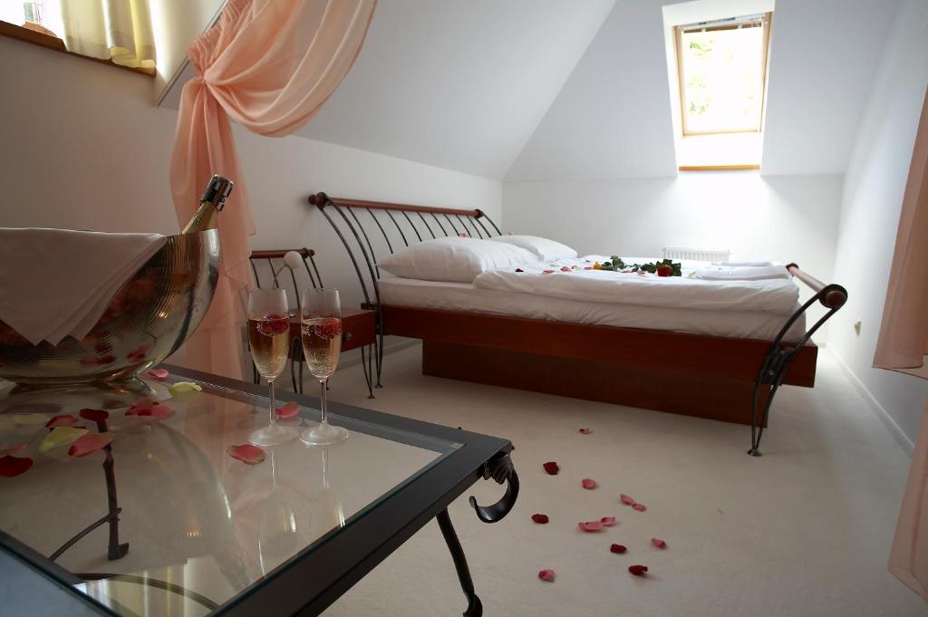 贝内绍夫科诺皮什切旅馆的一间设有床铺和玻璃桌及酒杯的房间
