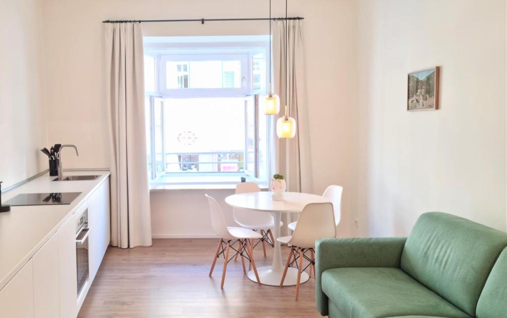 梅拉诺Rosa Apartment with parking historic city center的客厅配有桌子和绿色沙发