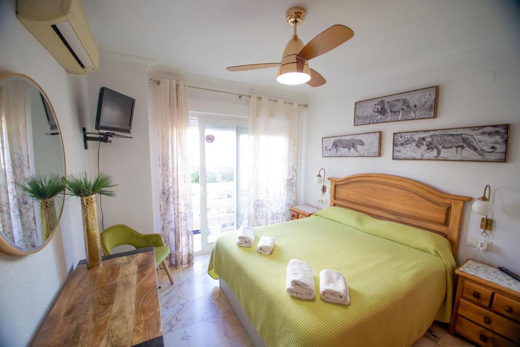 韦尔瓦"El Balcón de Huelva" lujo en pleno centro的一间卧室配有黄色的床和2条毛巾