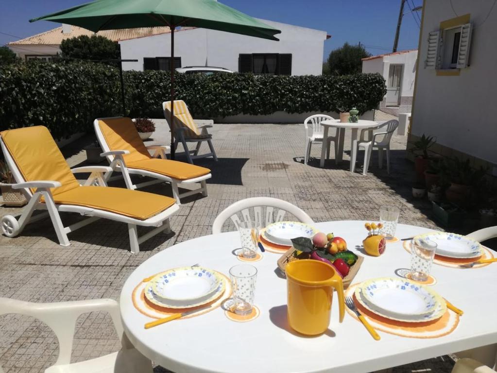 萨格里什Casa Oliveirinha - Sagres的庭院里一张带食物盘的白色桌子