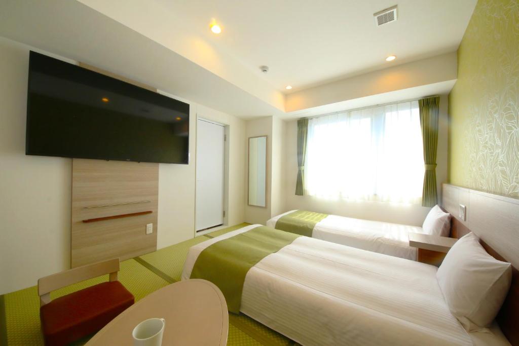 Kuretake Inn Premium Numazu Kitaguchi Ekimae客房内的一张或多张床位