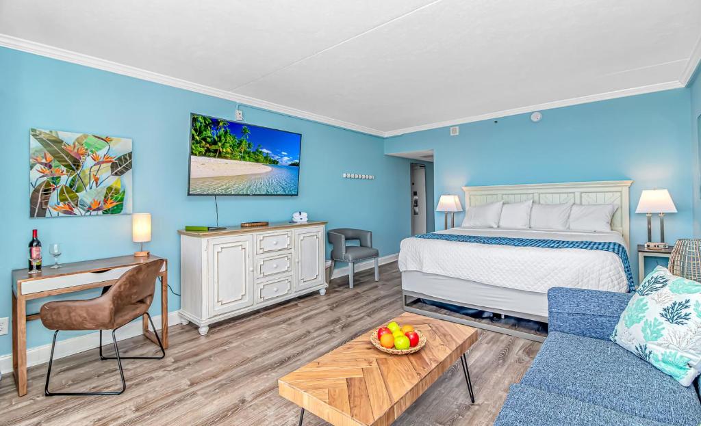 默特尔比奇Oceanfront Suite Grande Cayman 124的一间拥有蓝色墙壁的卧室,配有一张床和一张桌子