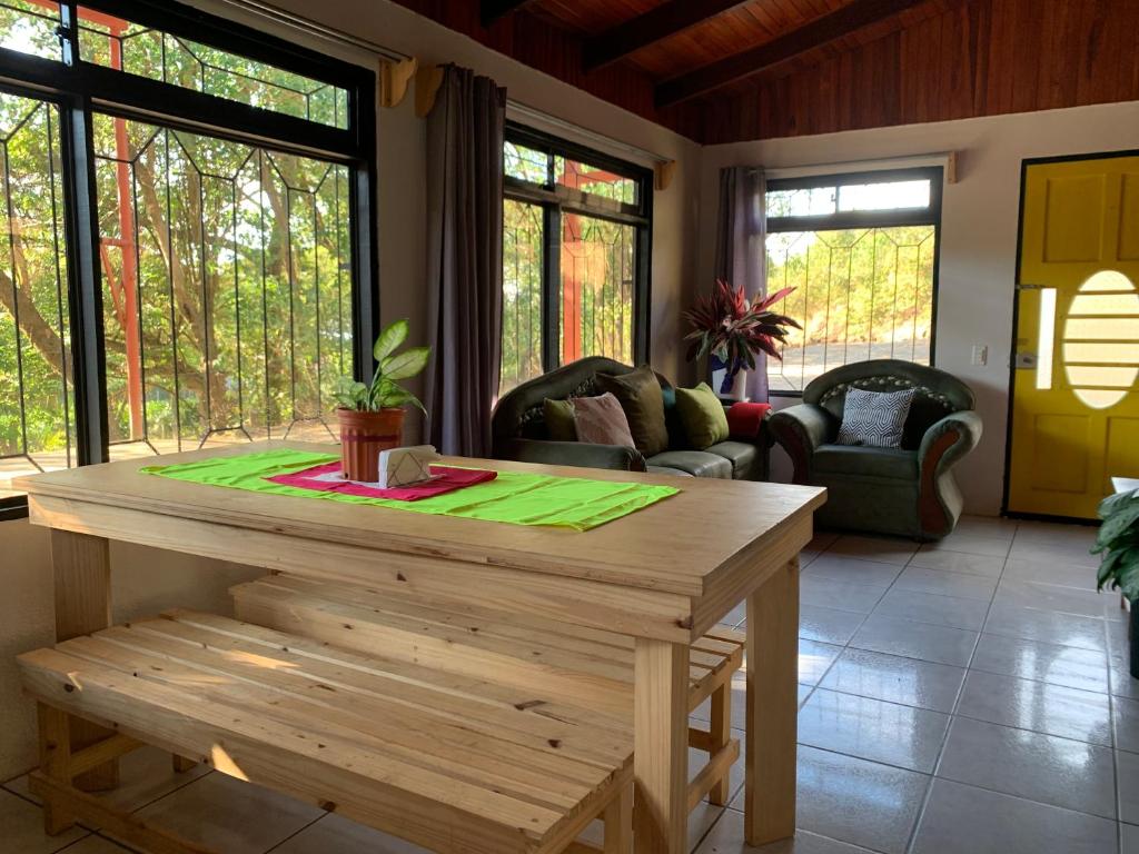 蒙泰韦尔德哥斯达黎加Hakuna Matata Guest House的客厅配有木桌和椅子
