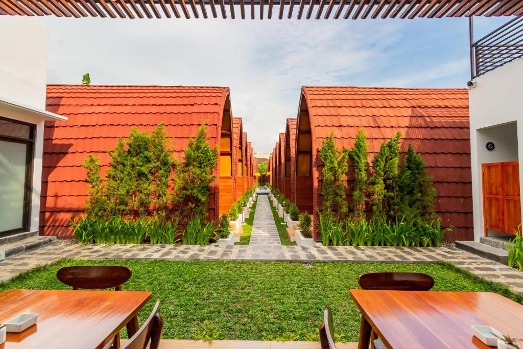 SeturanOmah Lumbung Yogyakarta的花园设有红色屋顶和木桌