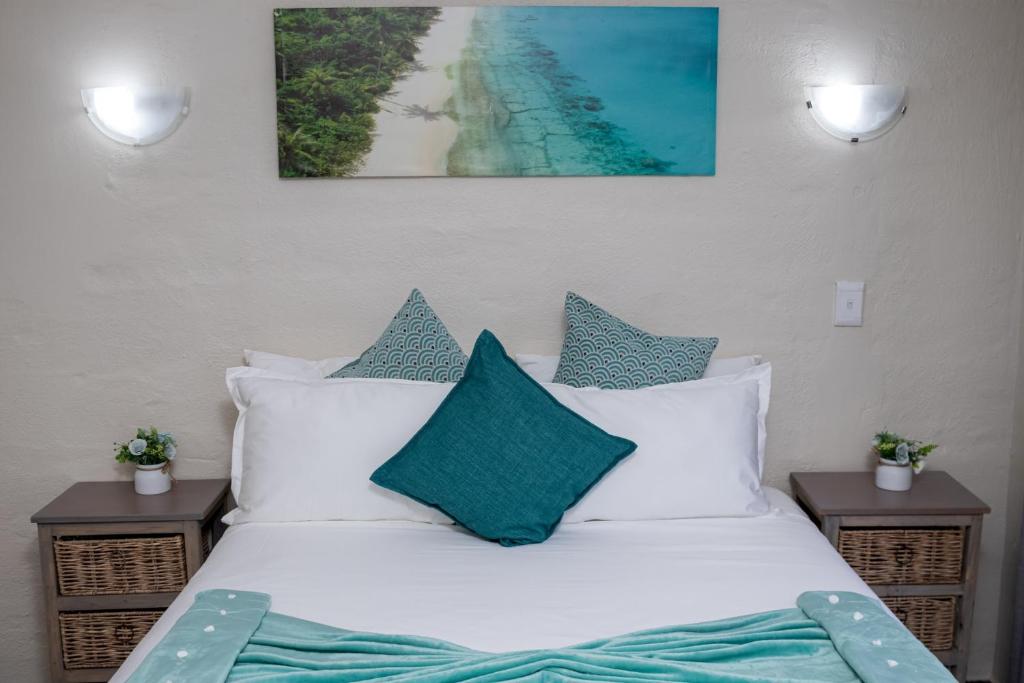 范德拜尔帕克Hillas Ridge Guesthouse的一张带白色枕头的床和一张海滩景
