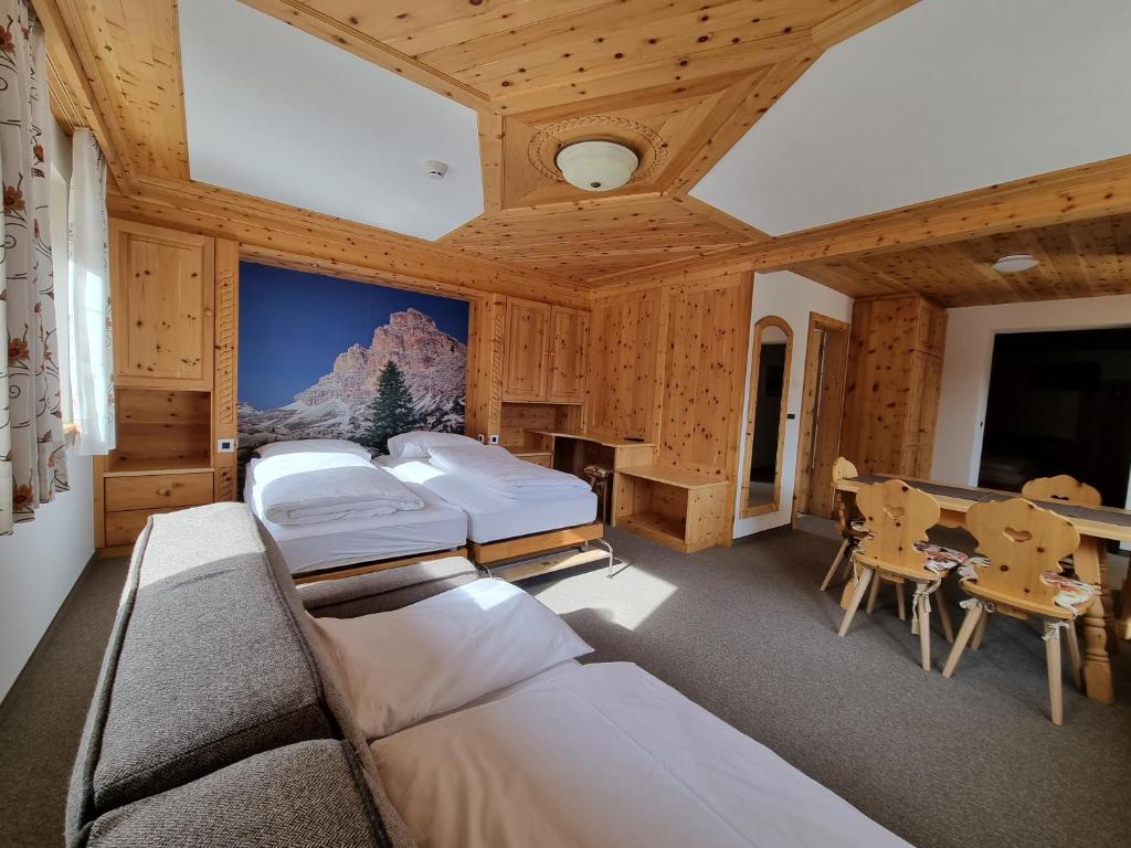 科尔福索博雷斯酒店的客房设有三张床、一张桌子和一张书桌