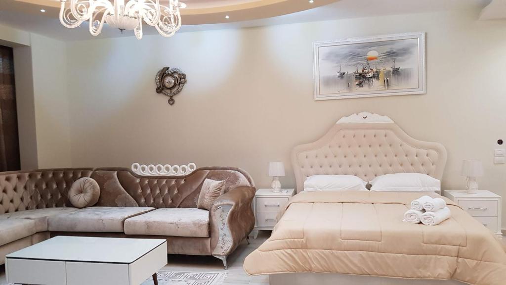 萨兰达罗马里奥公寓的一间卧室配有两张床、一张沙发和一个吊灯。