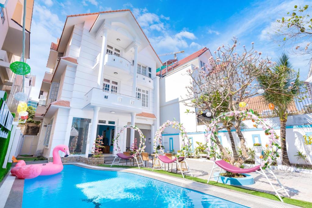 头顿Amy Villa 4 - Gần Biển - Bida - Karaoke - Phòng Xông Hơi的一座粉红色火烈鸟房子前的游泳池