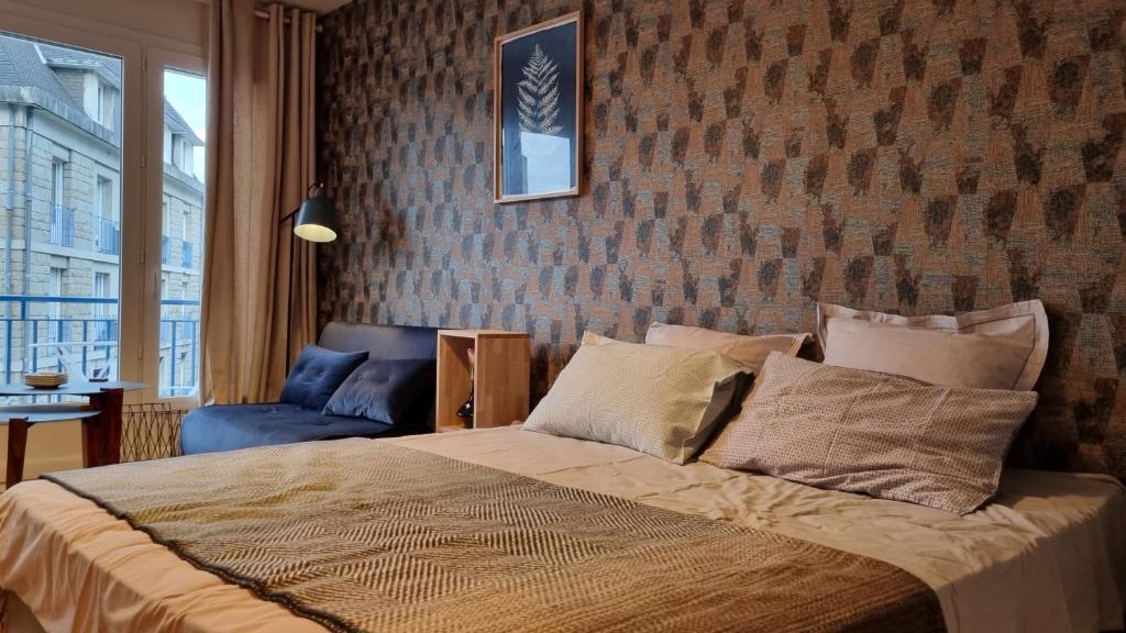 坎佩尔Studio Roy Gradlon Quimper的一间卧室设有一张床和砖墙