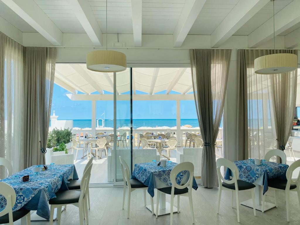 佩斯基奇Hotel Corona Beach Peschici的一间设有两张桌子的海景餐厅