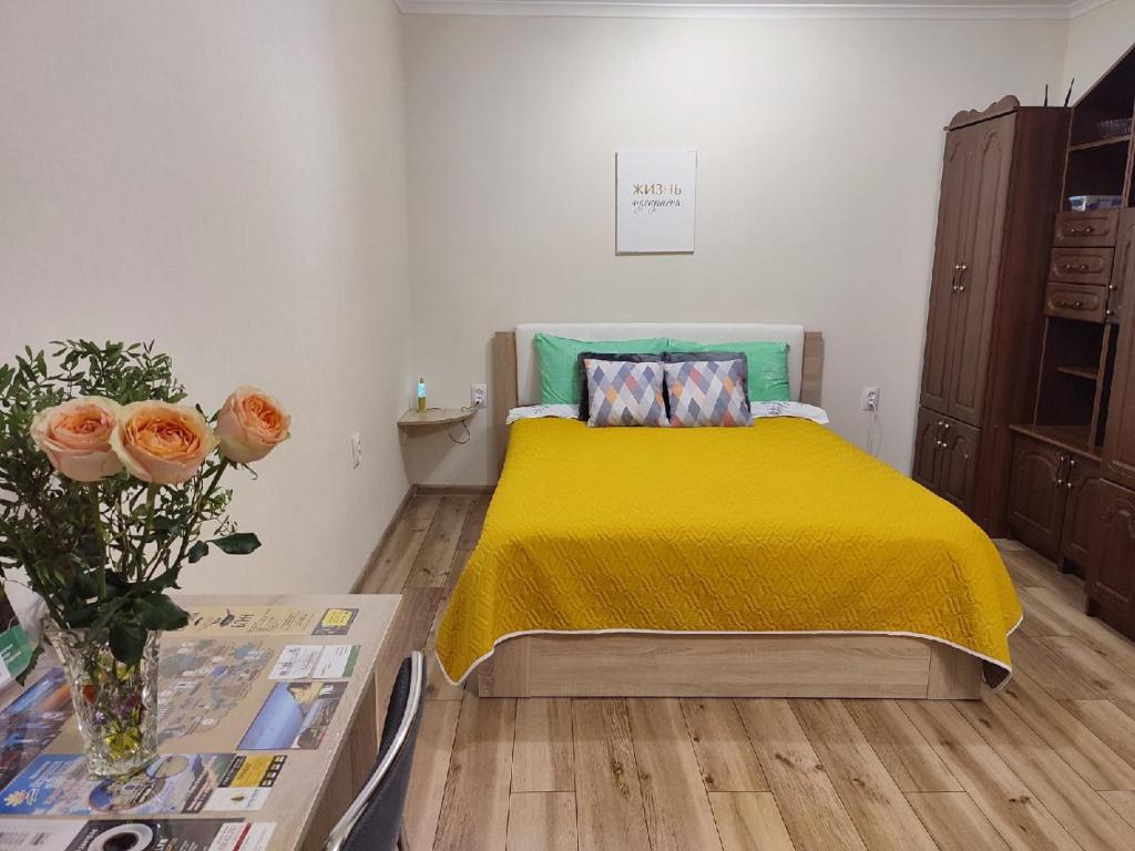 加里宁格勒Amber home的一间卧室配有一张带黄色床罩和桌子的床。