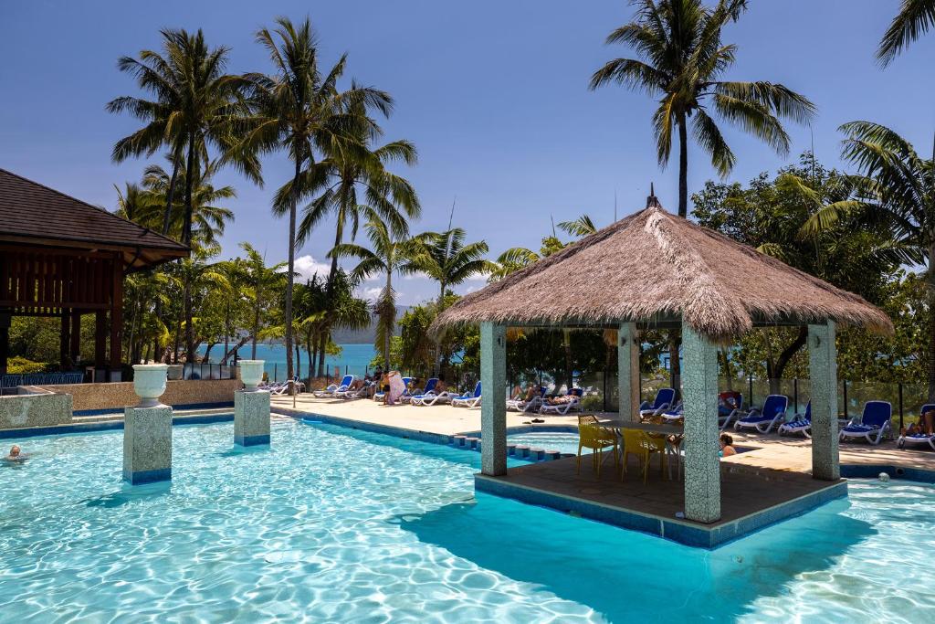 菲茨罗伊岛费兹洛伊岛度假酒店的一个带海滩和棕榈树的度假游泳池