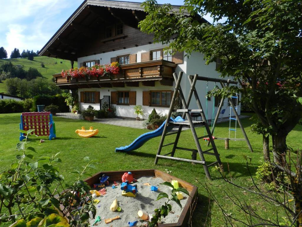 霍赫菲尔岑Gästehaus Glaagut - Familie Hain的一个带沙箱和游戏的院子和房子