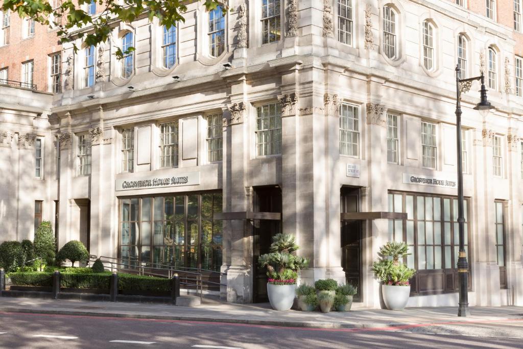 伦敦Grosvenor House Suites的一座白色的大建筑,前面有植物