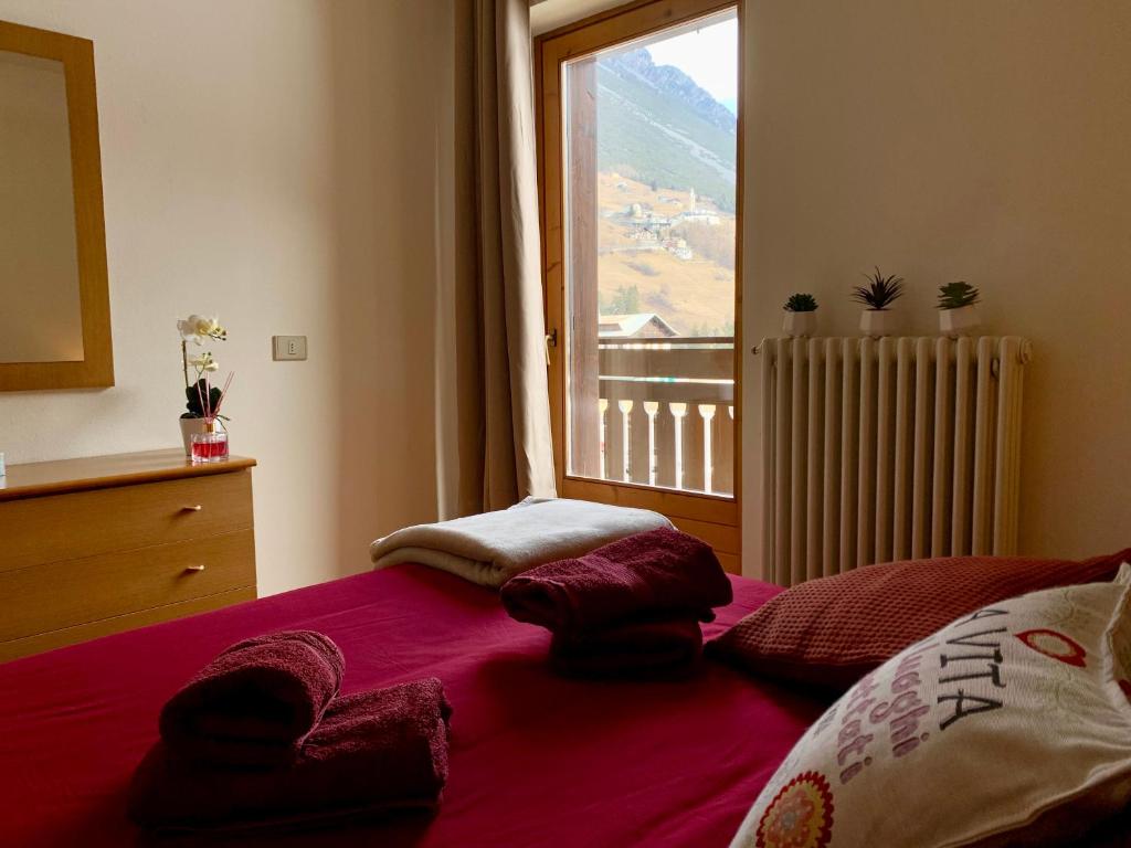 伊索拉察Cima de’ Piazzi Apartment的一间卧室设有一张大床和大窗户