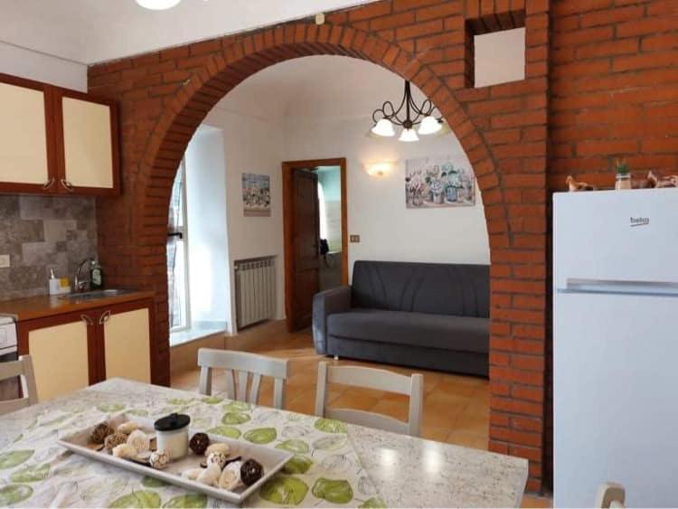 菲乌吉Alloggio Turistico Lidia的厨房以及带桌子和拱门的客厅。