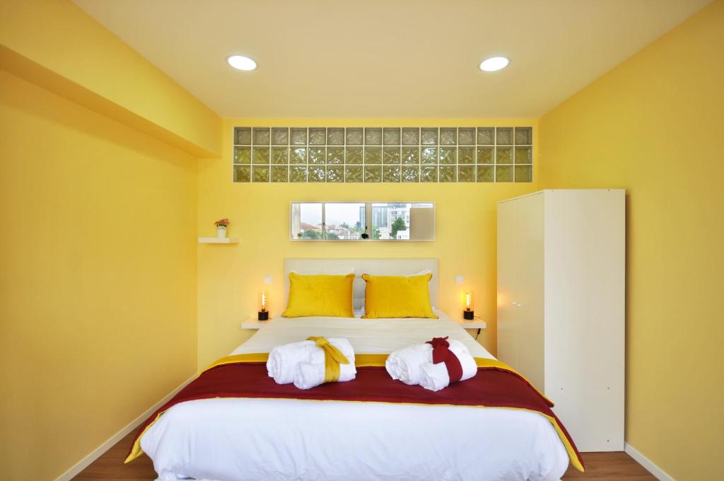 布拉加RH Charming Apartment Liberdade II的一间卧室设有一张黄色墙壁的大床