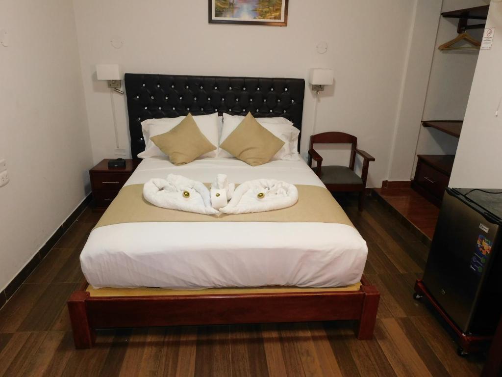 马尔多纳多港Hotel Tambopata Inn的一间卧室配有带毛巾的床