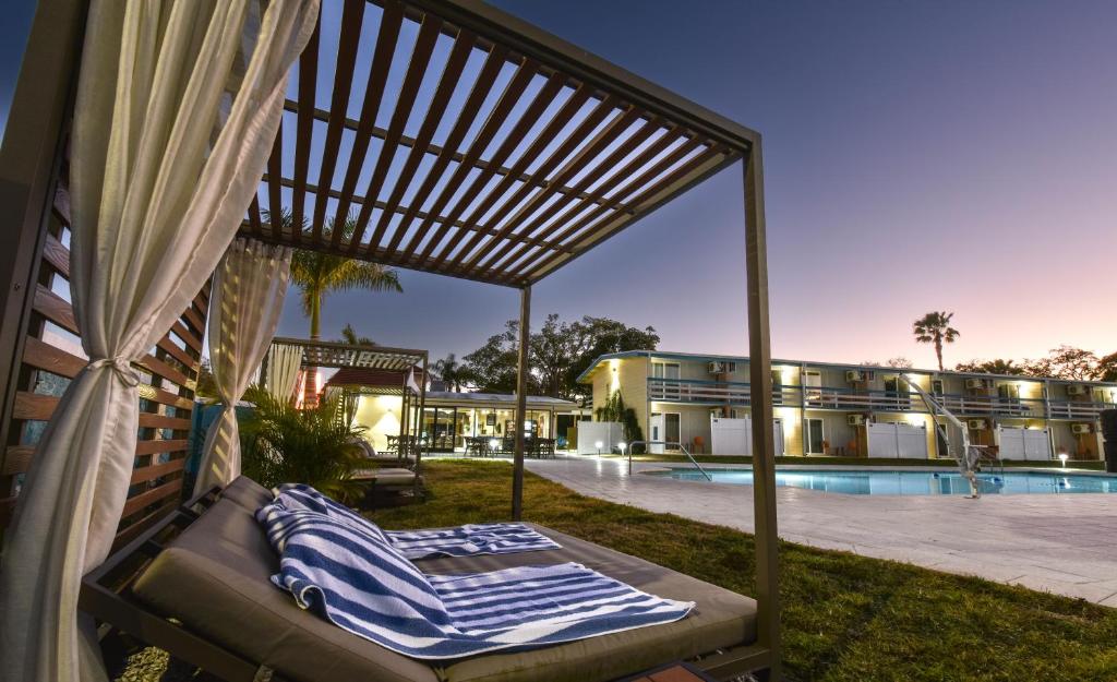 萨拉索塔Golden Host Resort Sarasota的游泳池前的门廊秋千