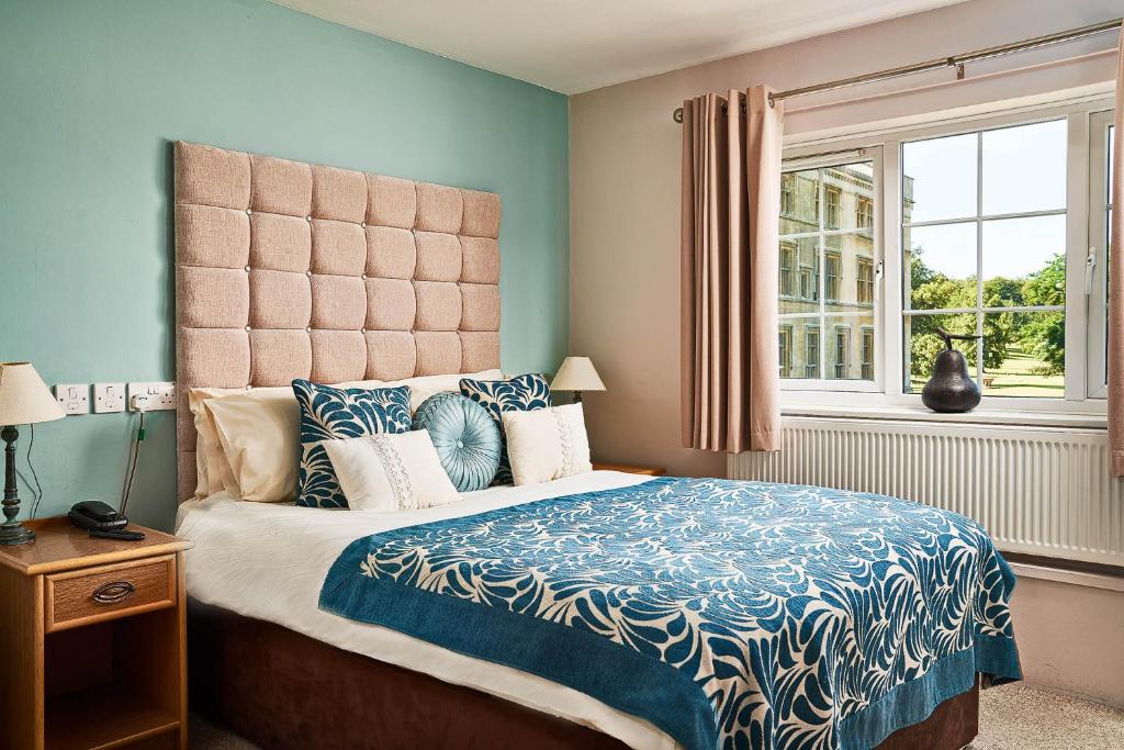 Old WardenThe Garden Suite at Shuttleworth的一间卧室配有一张带蓝色和白色棉被的床
