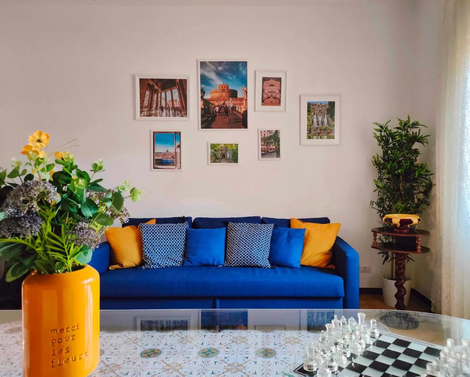 罗马Non ti scordar di me - Granny's House的客厅配有蓝色的沙发和墙上的照片