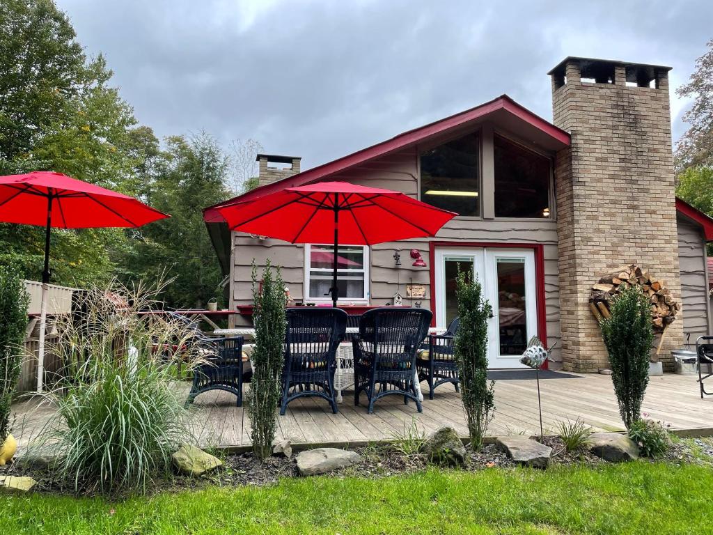 RoscoeRoscoe Cabin Pet friendly的一座配有红色遮阳伞和桌椅的房子