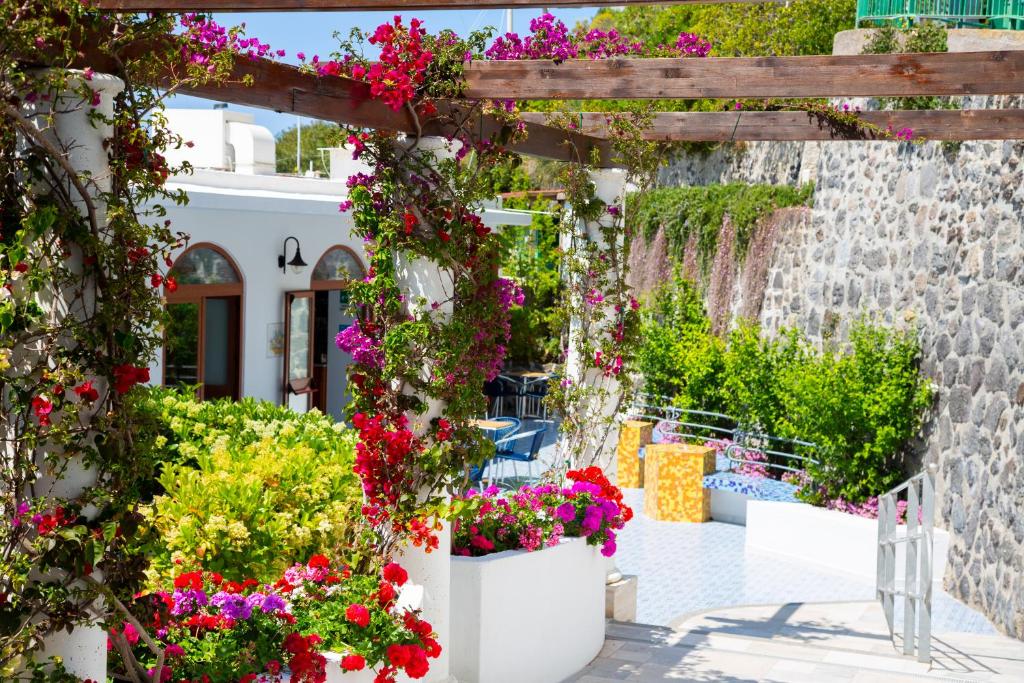 伊斯基亚拉曼多拉酒店的一座花园,在一座建筑前方的盆里种着鲜花