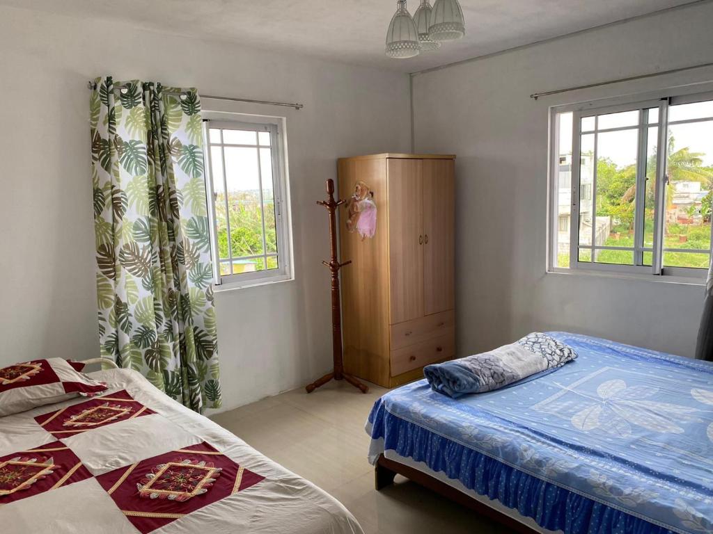 HenriettaGreen Discovery B&B Tamarind Falls 7 Cascades的一间卧室设有两张床和两个窗户。