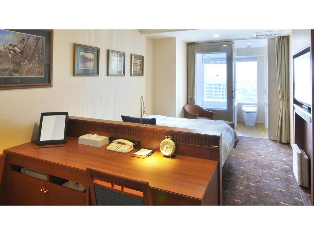 草津町Boston Plaza Kusatsu Biwa Lake - Vacation STAY 15434v的酒店客房配有书桌和床。