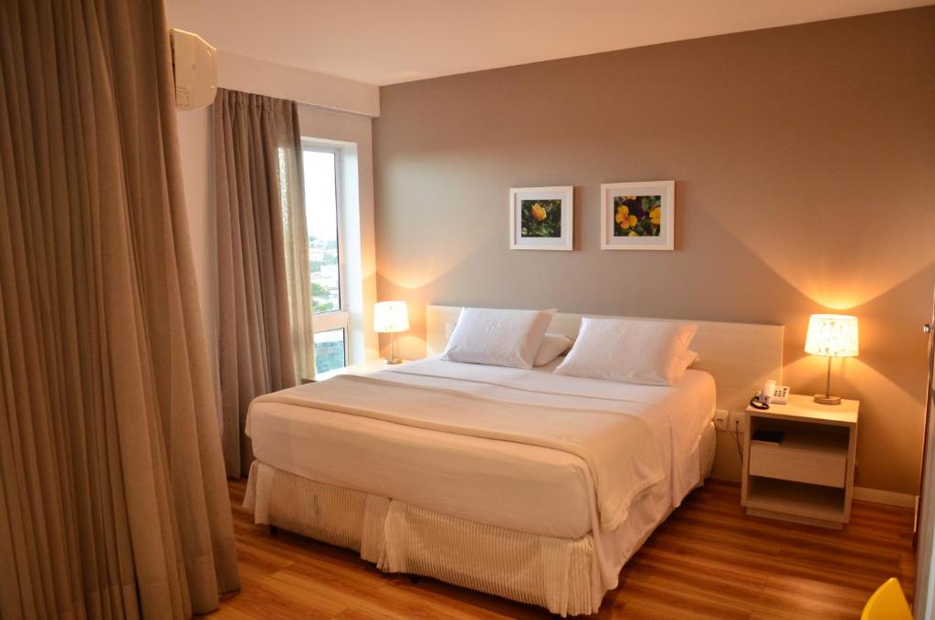费拉迪圣安娜Unico Apart Hotel的卧室配有白色的床和窗户。