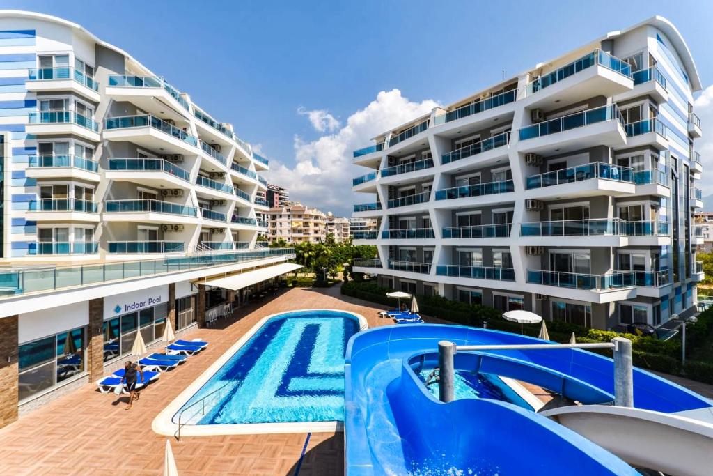 阿拉尼亚SA Apartments! Crystal Family Suites的一个带游泳池和大楼的公寓
