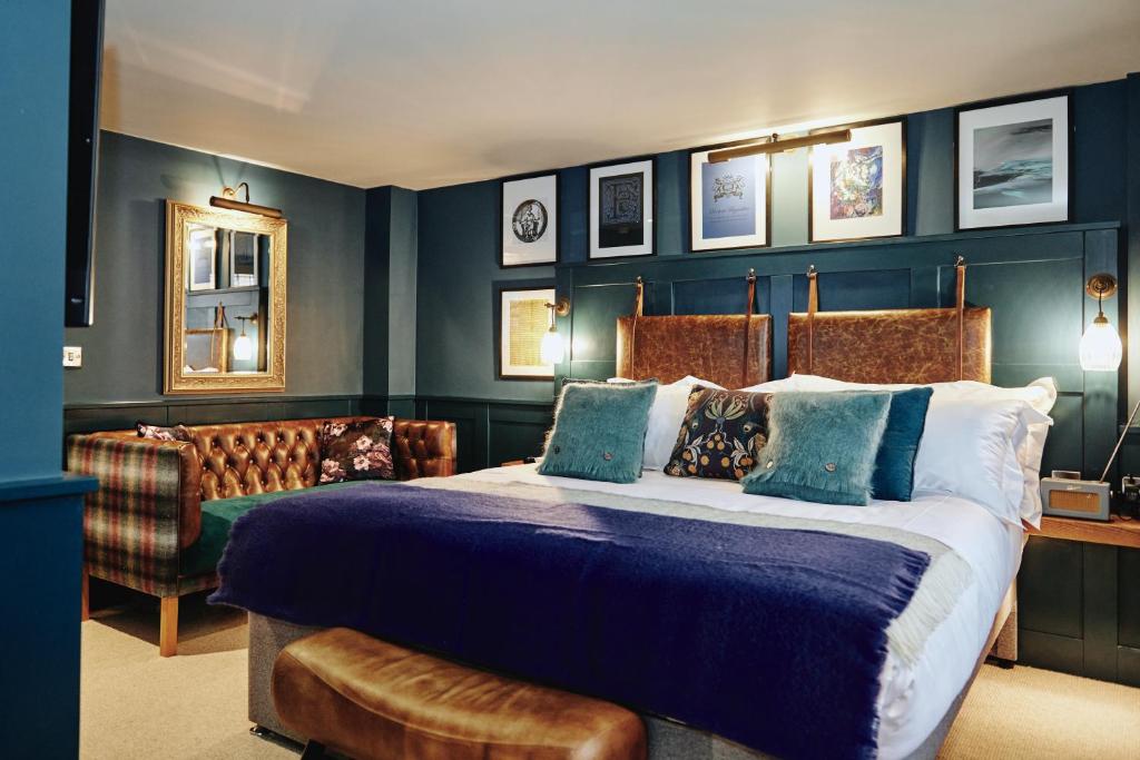 埃格姆Kings Arms的一间卧室配有一张大床和一张沙发