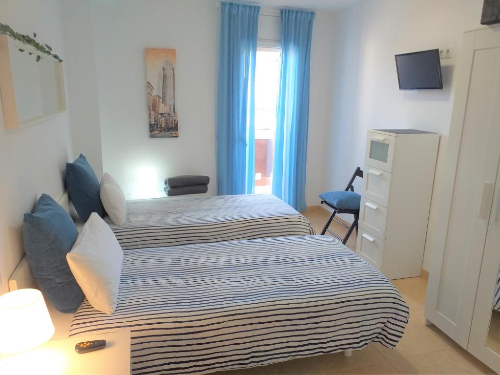 赫罗纳CENTRICO y ACOGEDOR APARTAMENTO的一间卧室设有两张床和窗户。