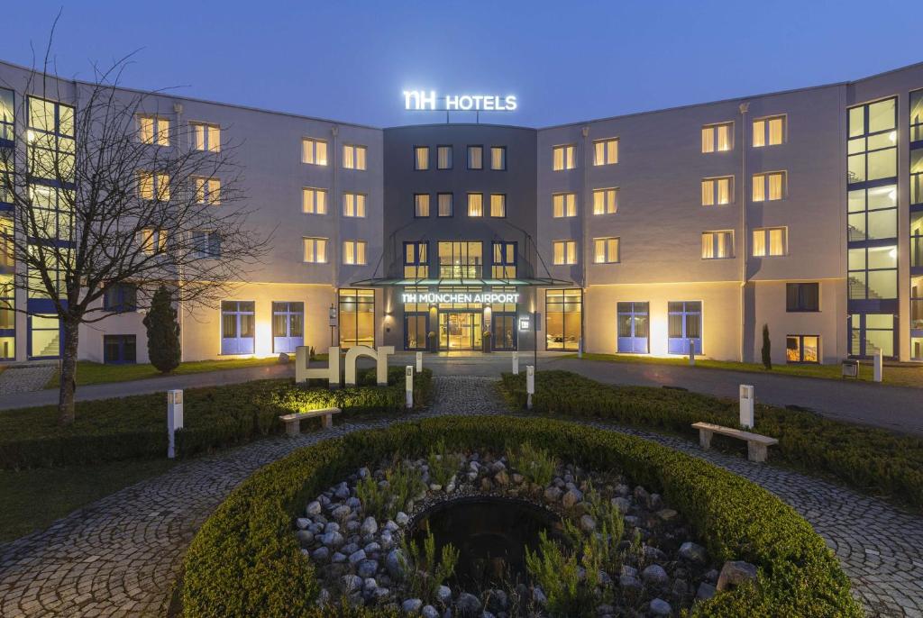奥伯丁NH酒店慕尼黑机场店的一座酒店大楼,前面设有花园