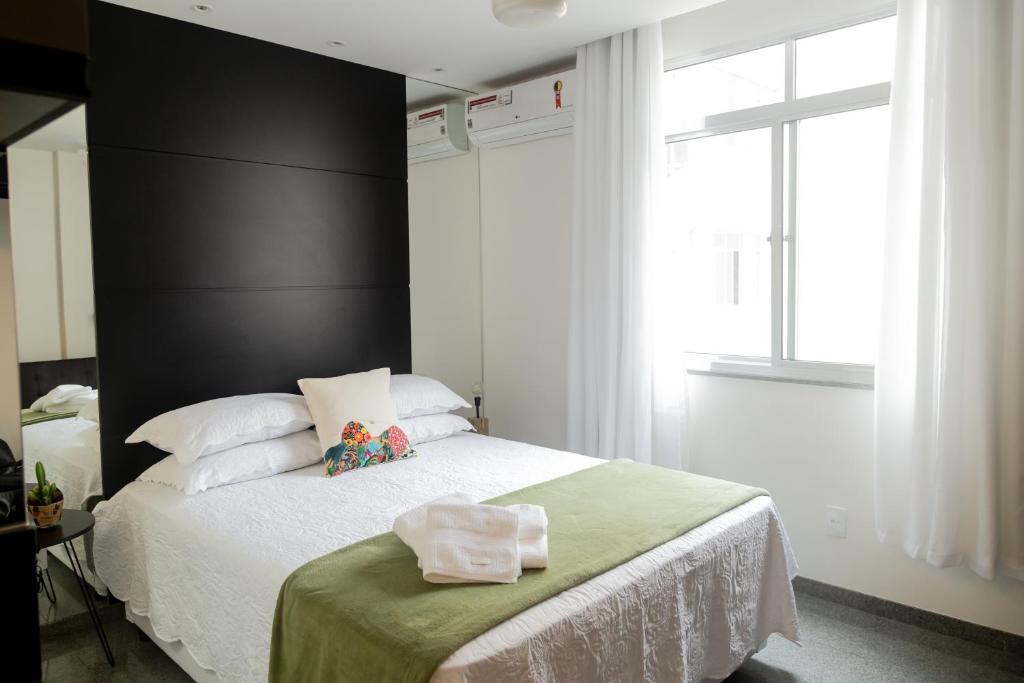 里约热内卢Ipanema 309 Studio的一间卧室配有一张大床和黑色床头板