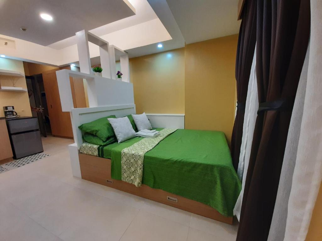 利帕1Tagaytay的一间卧室配有一张带绿毯的床