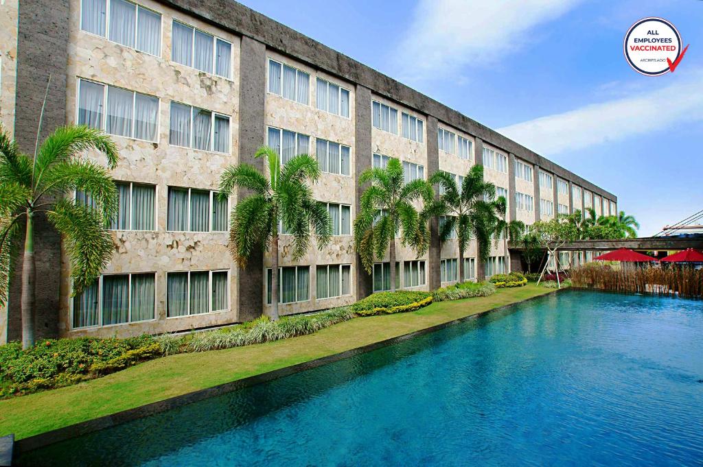 登巴萨ASTON Denpasar Hotel & Convention的建筑前的一座带游泳池的建筑