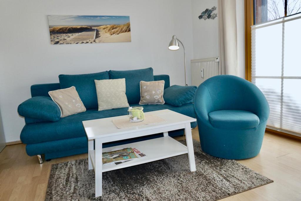 达默Kajüte 5的客厅配有蓝色的沙发和桌子