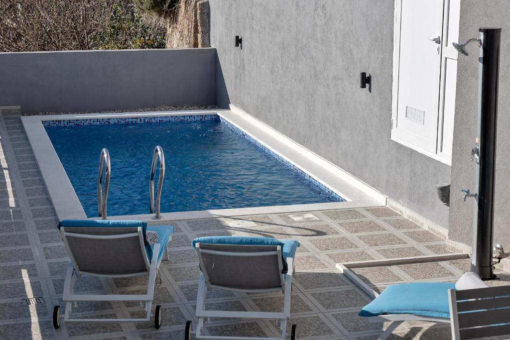 马卡尔斯卡Apartment Lotte with private pool in the city center!的一个带两把椅子和一张桌子的游泳池