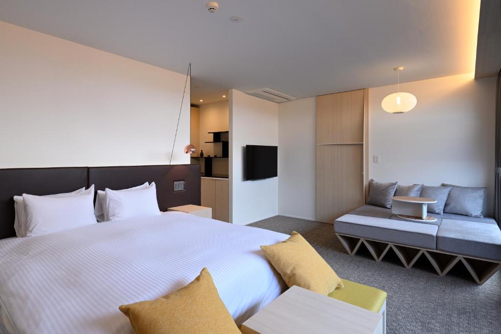 京都HOTEL KYOTOLOGY的酒店客房设有一张大床和一张沙发。