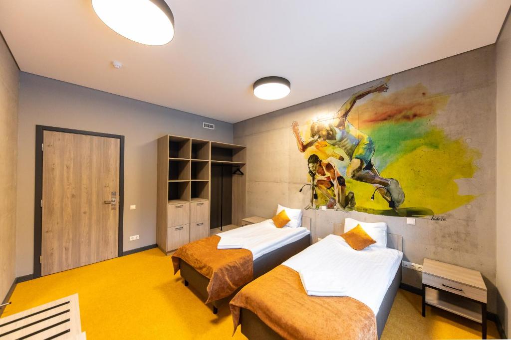 瓦尔米耶拉Stadium Hotel的墙上画画的房间里设有两张床
