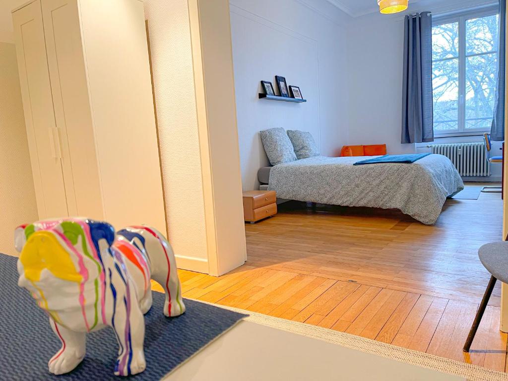 米卢斯Chambres privées -Private room- dans un spacieux appartement - 100m2 centre proche gare的卧室在地毯上饲养着玩具狗