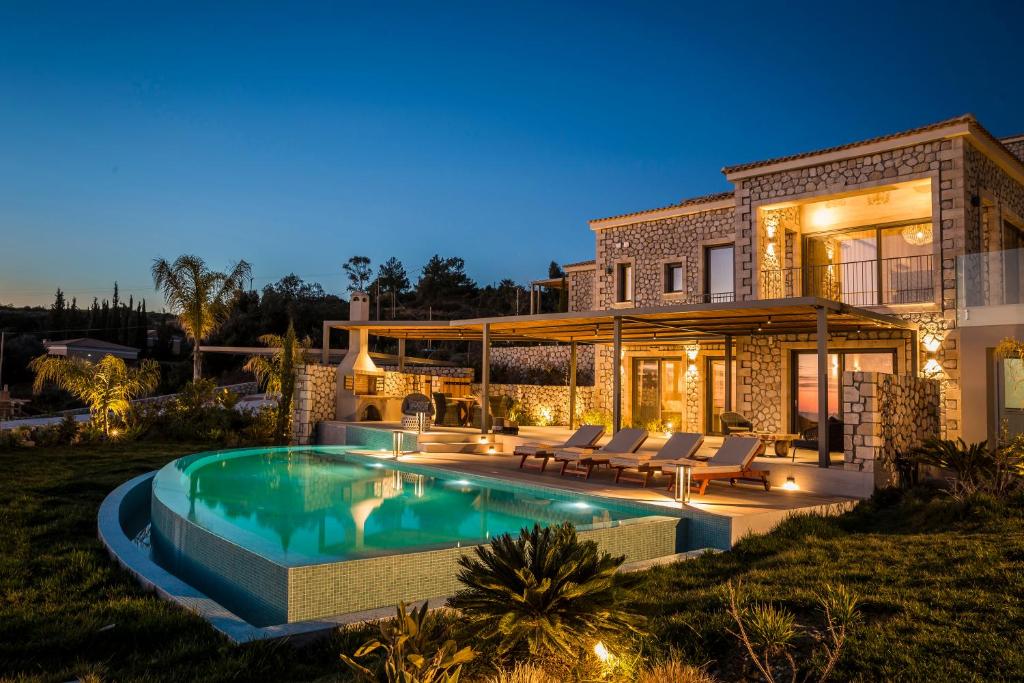 斯巴达Zeus Exclusive Villas的一座房子前面设有游泳池