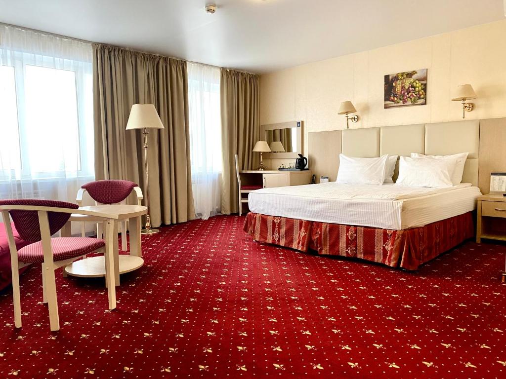克拉斯诺亚尔斯克阿马克斯城市酒店的酒店客房,配有床铺和红地毯
