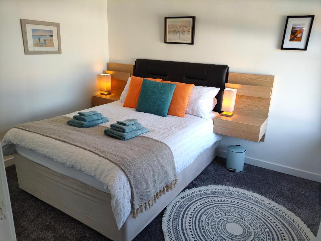 斯特罗姆内斯Stromness Apartments的一间卧室配有带橙色和蓝色枕头的床