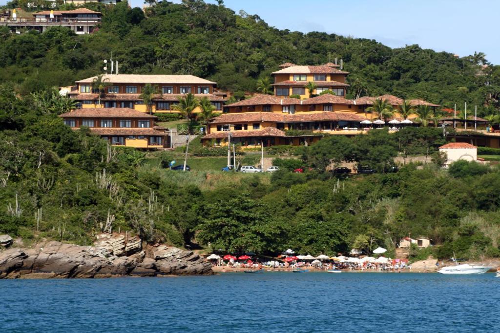 布希奥斯Colonna Galapagos Garden Hotel的水体旁的山丘上的度假胜地