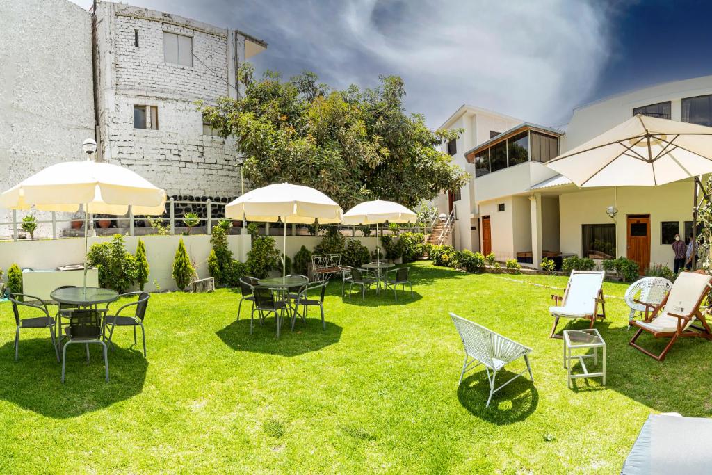 阿雷基帕Hotel El Turista的一个带桌椅和遮阳伞的庭院