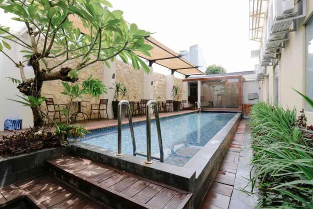 马卡萨Favor Hotel Makassar City Center By LIFE的一座建筑物中央的游泳池