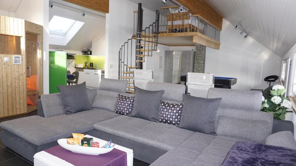黑里绍Loft in der Natur mit Gartenzugang und Sauna的客厅设有灰色的沙发和楼梯。